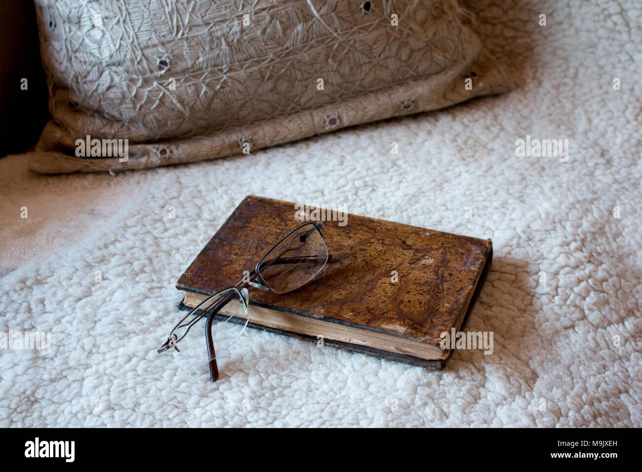 Buch und Brille auf der Couch Stockfoto
