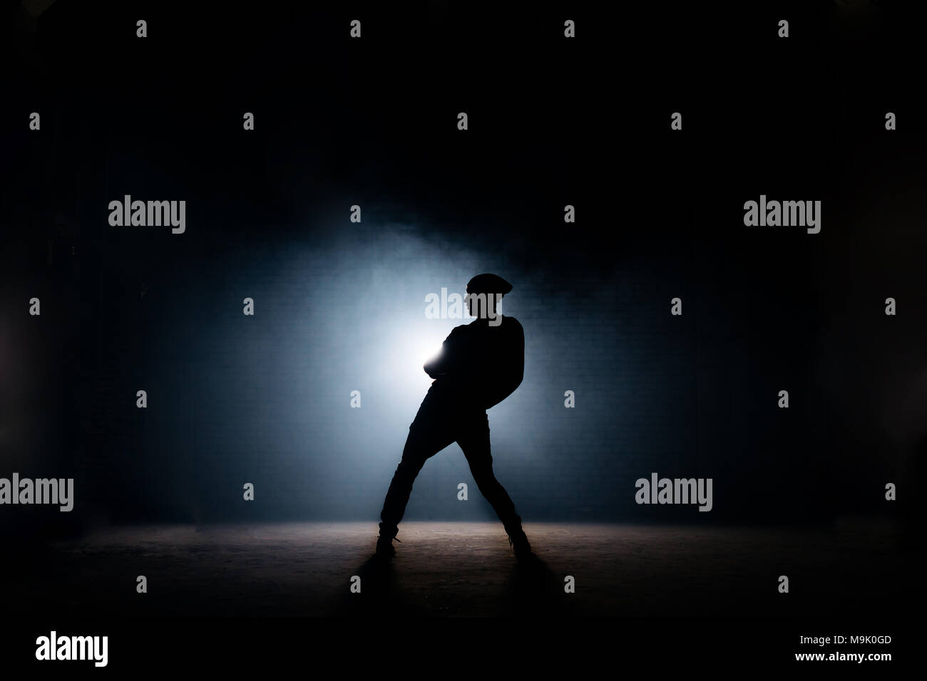 Junge männliche Tanzen auf dunkler Bühne. erste Leistung. Körper gebogen. Street Dance Stockfoto