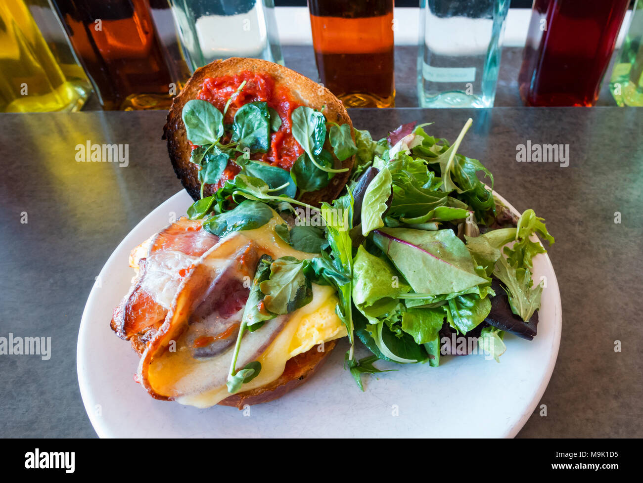 Ei und Speck Sandwich auf einer weichen gerösteten Roll mit gemischten Salat Stockfoto