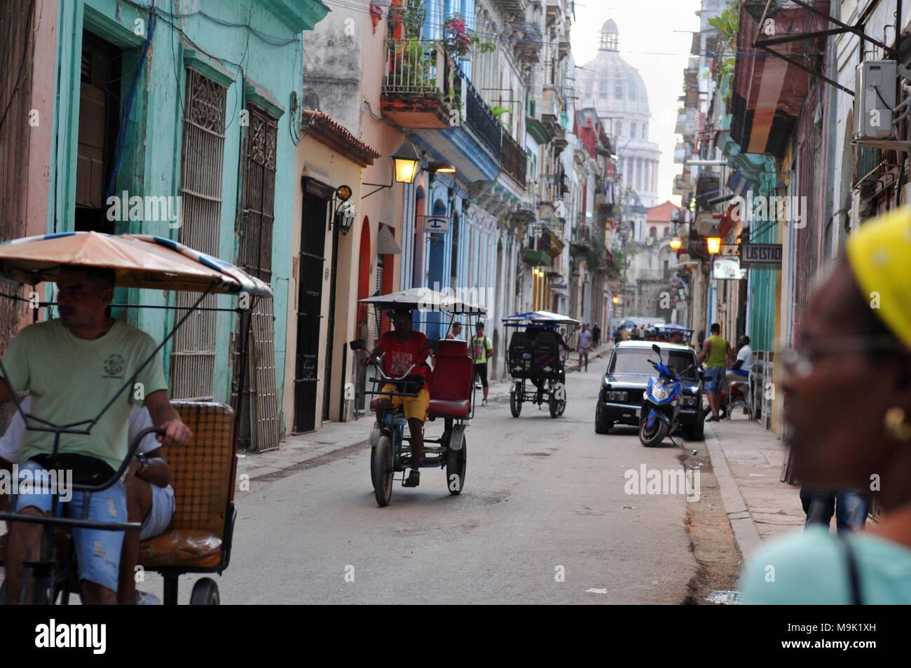 Die Kuppel des Capitolio Nacional (Capitol) über eine Straße besetzt mit Fußgängern und Fahrrad Taxi in die Altstadt von Havanna, Kuba. Stockfoto