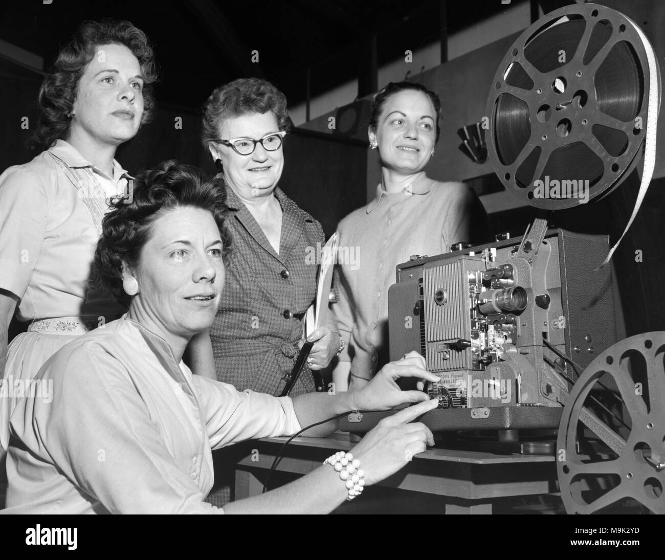 Auch wenn der Film nicht angezeigt wird durch den Film Projektor eingefädelt werden, vier Frauen scheinen begeistert zu sein, mit dem Film, Ca. 1960. Stockfoto