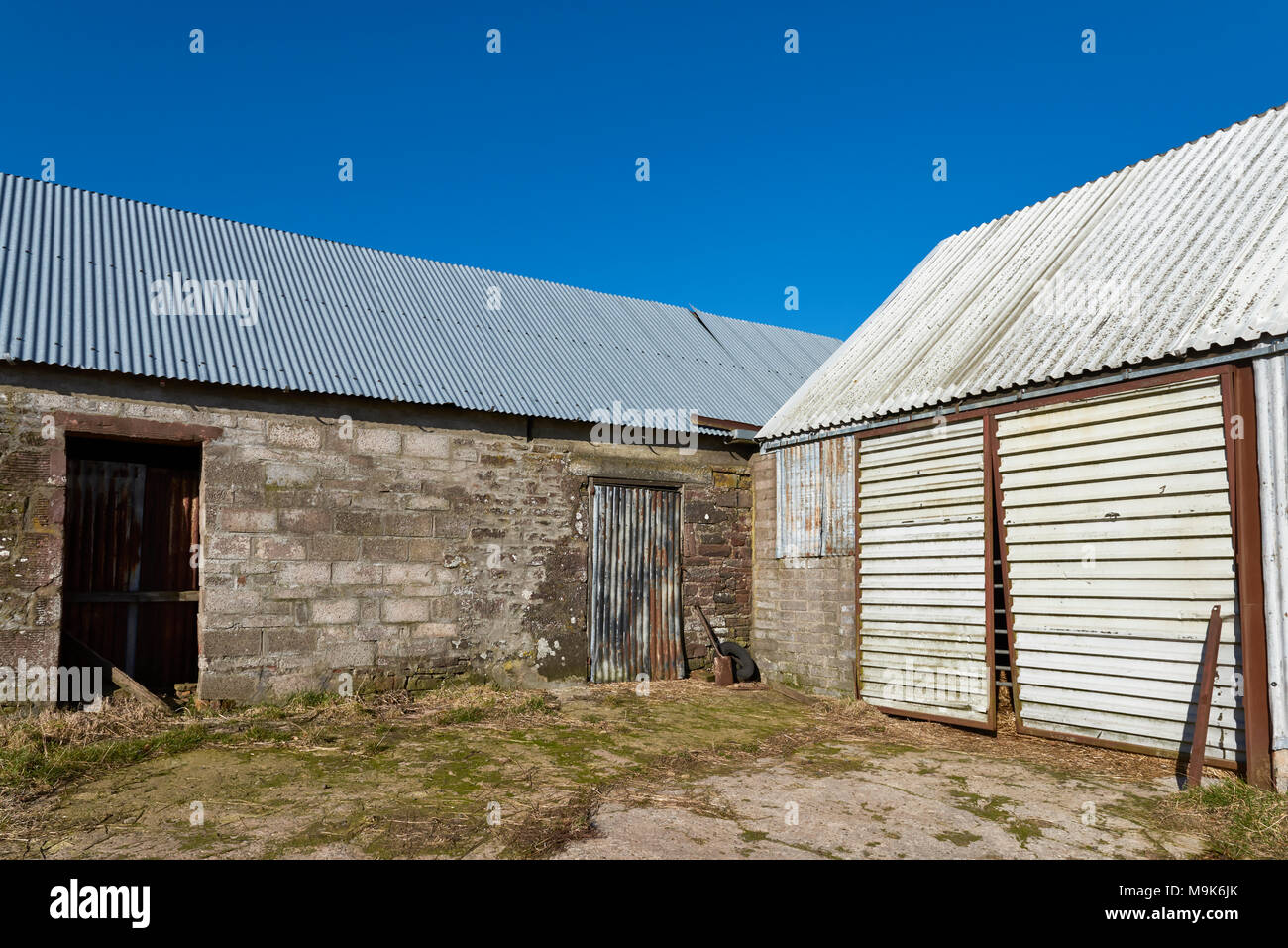 Eine Ecke von einen unordentlichen Hof in einer Reihe von alten, umgebauten Bauernhaus in der Nähe von Dunnichen in Angus, Schottland, die helle Sonne schlagen auf die Stockfoto