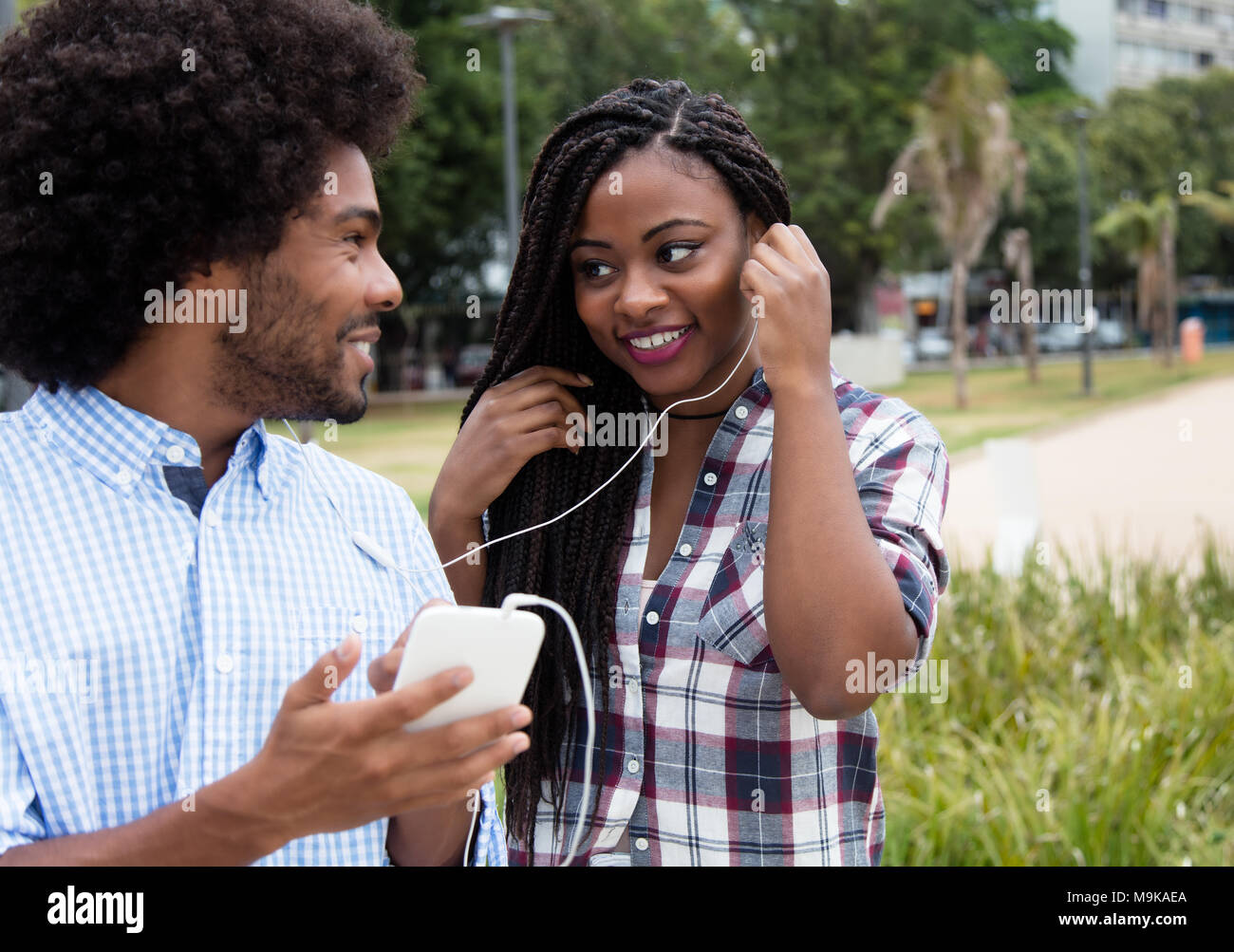 Afrikanische amerikanische Frau genießt Musik mit hipster Freund draußen in der Stadt Stockfoto