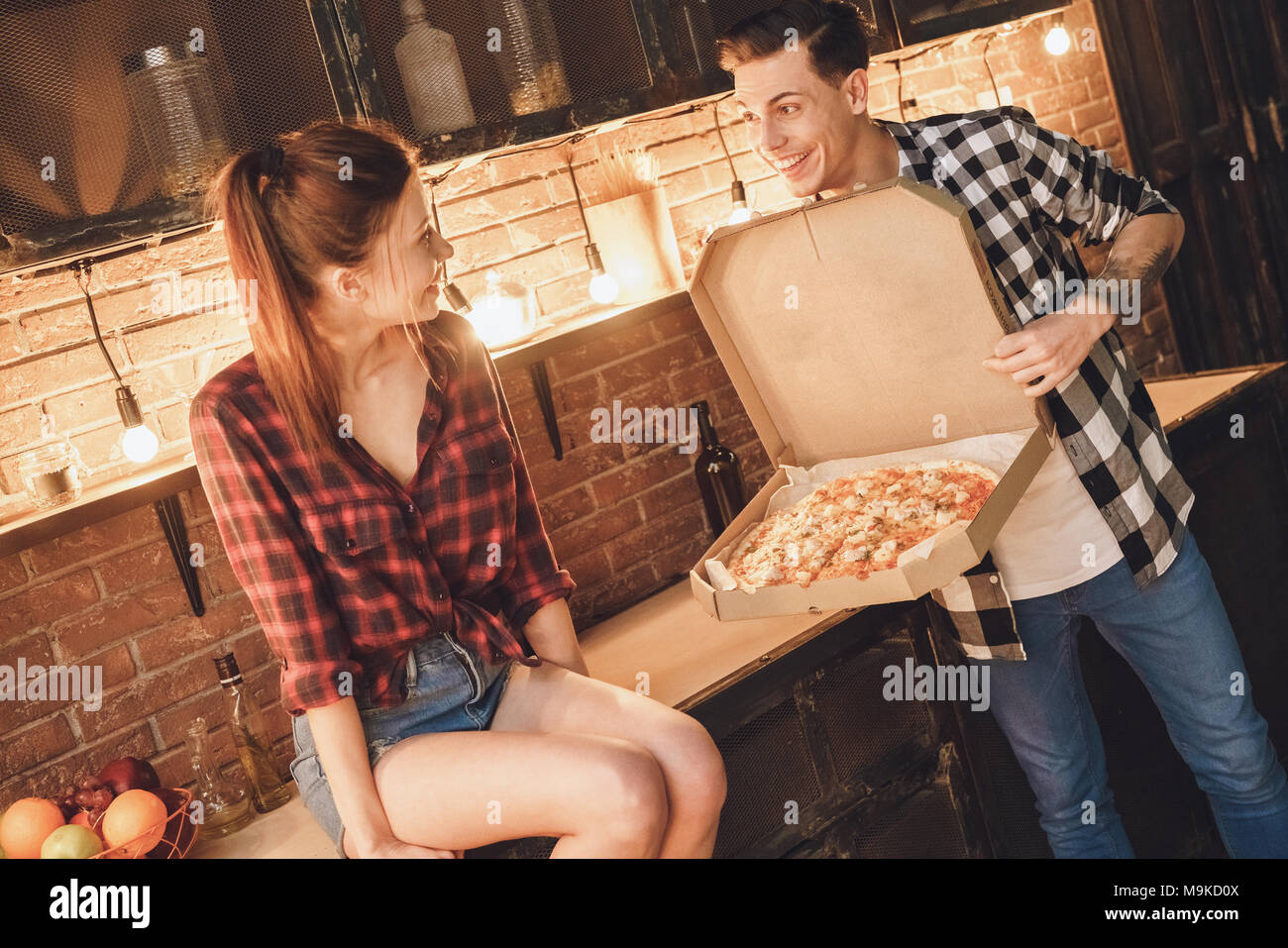 Mann big Pizza kaufen. Frau shoked. Hallenbad, Küche Home Interior, Studio gedreht. Stockfoto