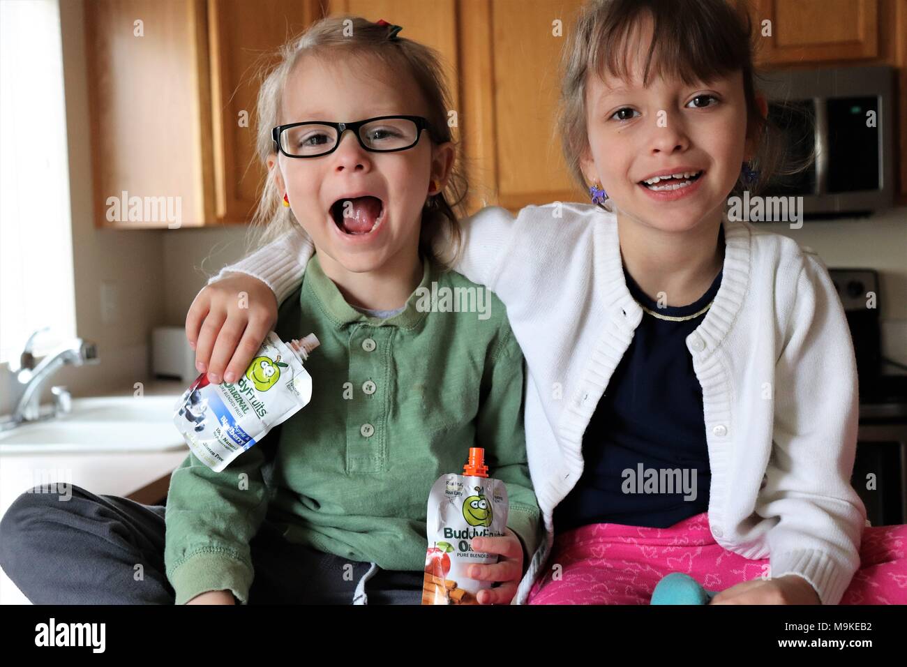 Schwestern genießen Buddy Obst in der Küche Stockfoto