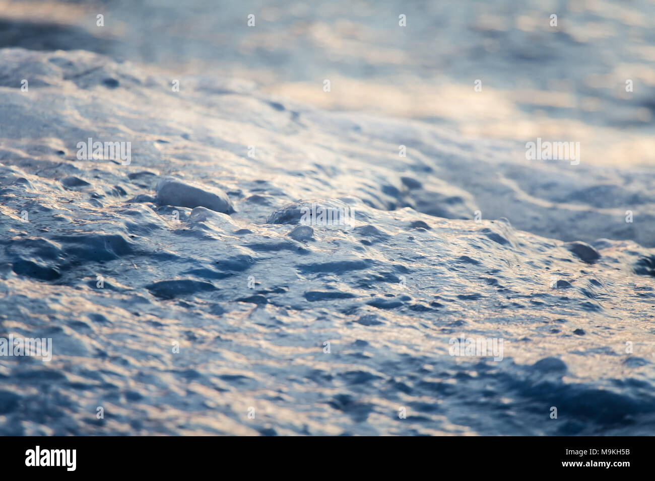 Eine schöne Nahaufnahme eines gefrorenen Meer Wasser an der Küste der Ostsee. Gefrorenes Salzwasser vawes auf einem Strand. Abstrakte closup aus Eis. Stockfoto