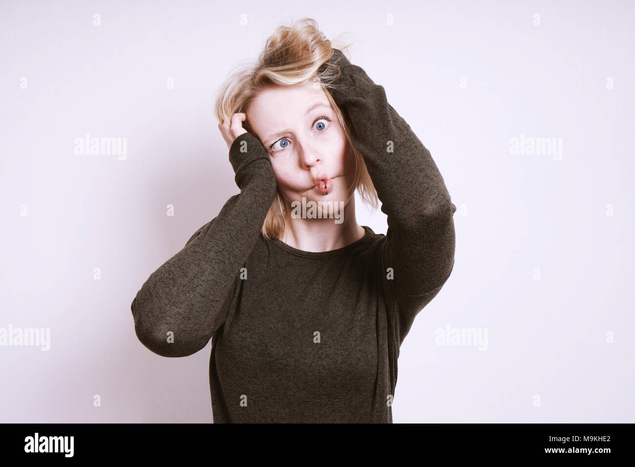 Dumme junge Frau Scherz um und Grimassen Stockfoto