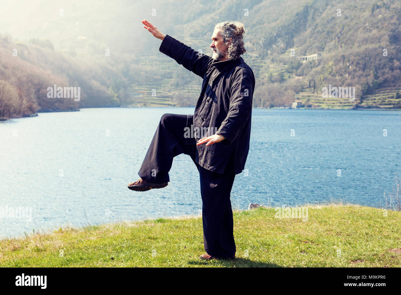 Reife Männer üben von Tai Chi Disziplin im Freien in einem See Park an einem Wintertag Stockfoto