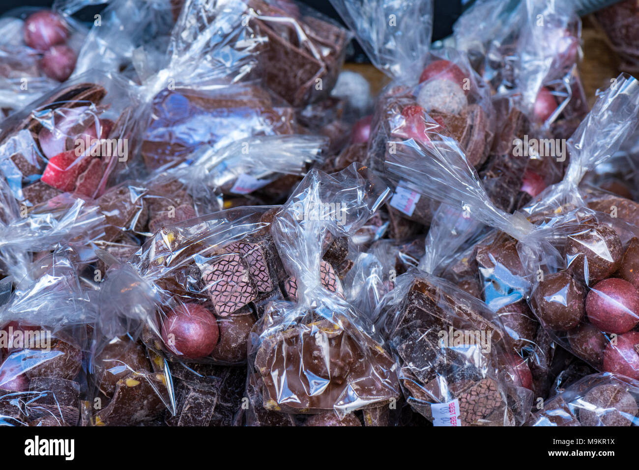 Ostern Schokolade und Eier high class Schokolade Süßwaren in durchsichtigen Wrapper in farbiges Papier gewickelt. Spezialitäten zum Verkauf auf einem Stall. Stockfoto