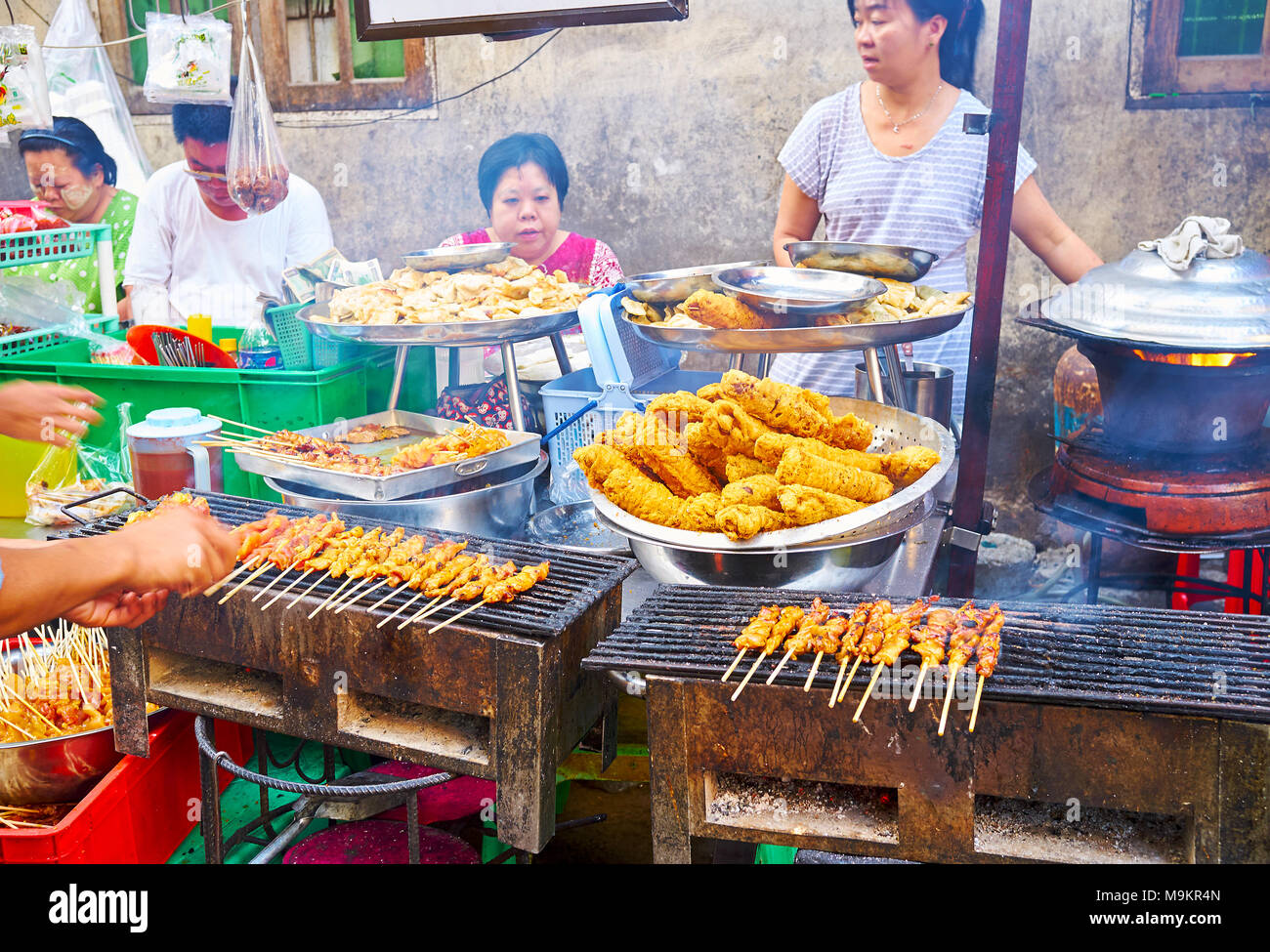 YANGON, MYANMAR - Februar 14, 2018: Kochen von Grill Huhn, gegrilltes Fleisch am Spieß, der chinesischen Teigtaschen und anderen beliebten Street Food in Chinatow Stockfoto