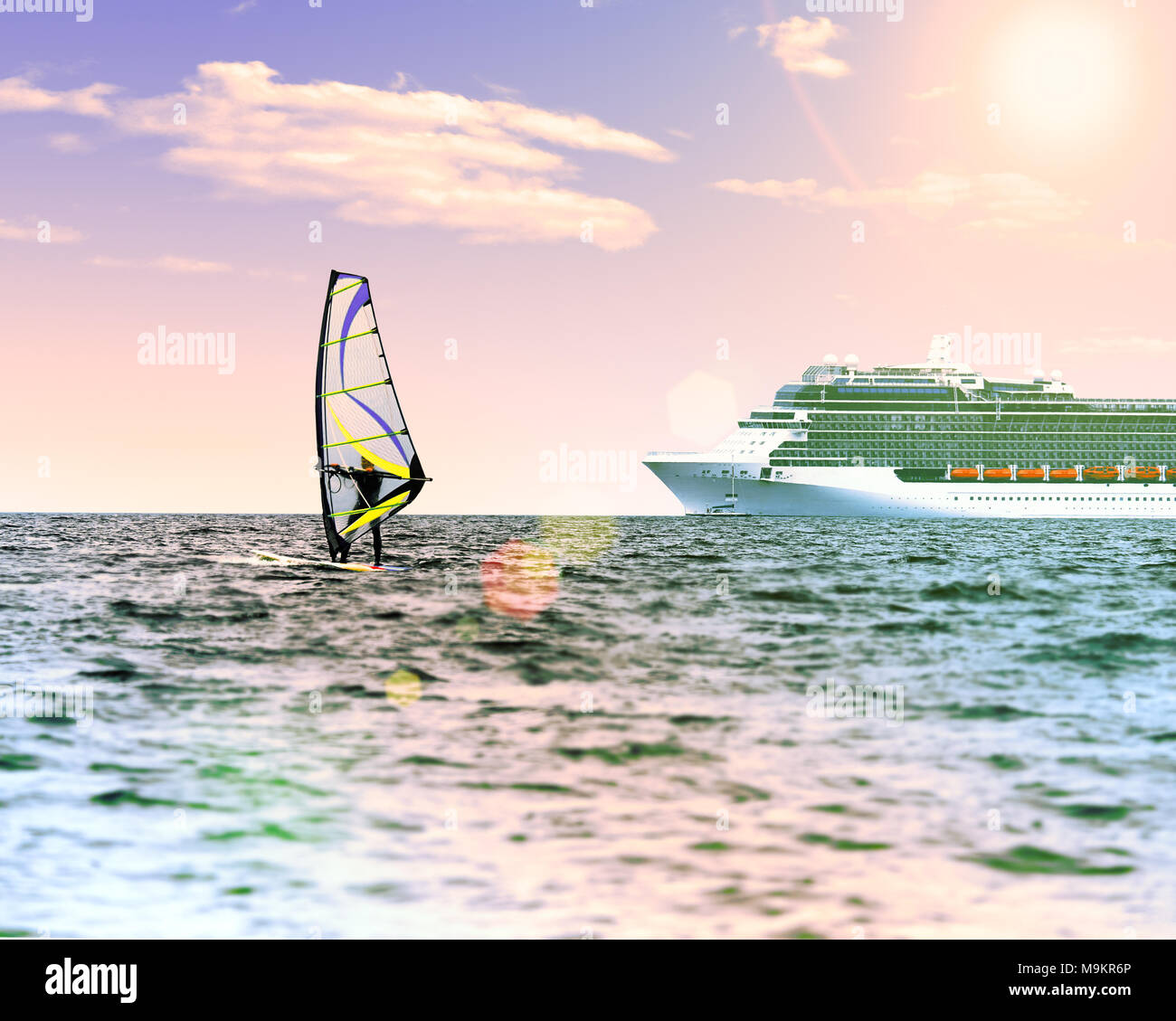 Windsurfer im Meer mit einem Kreuzfahrtschiff auf backgroung. Rosa getönt, lens flare Sonne, Sonne am blauen Himmel. Aktiver sport Ferienhäuser Konzept. Stockfoto