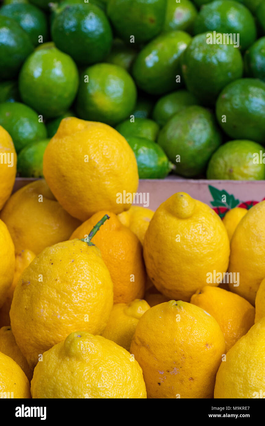 Zitronen und Limonen gestapelt hoch auf einem am Borough Market in Central London. Zitrone und Limette frische Aromen und bunte Anzeige auf einen Stall Gemüsehändler. Stockfoto