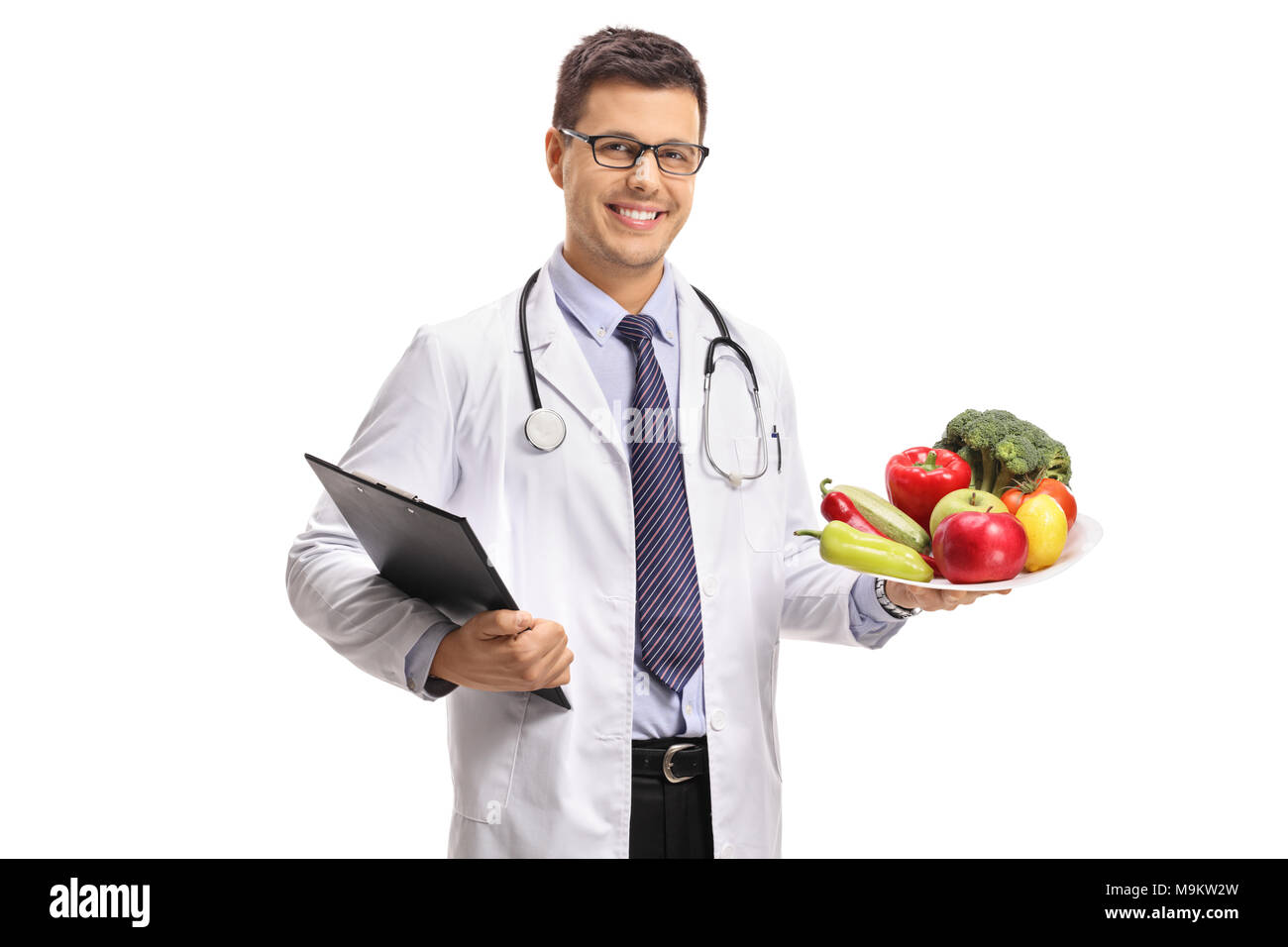 Arzt eine Zwischenablage und einen Teller mit Obst und Gemüse auf weißem Hintergrund Stockfoto