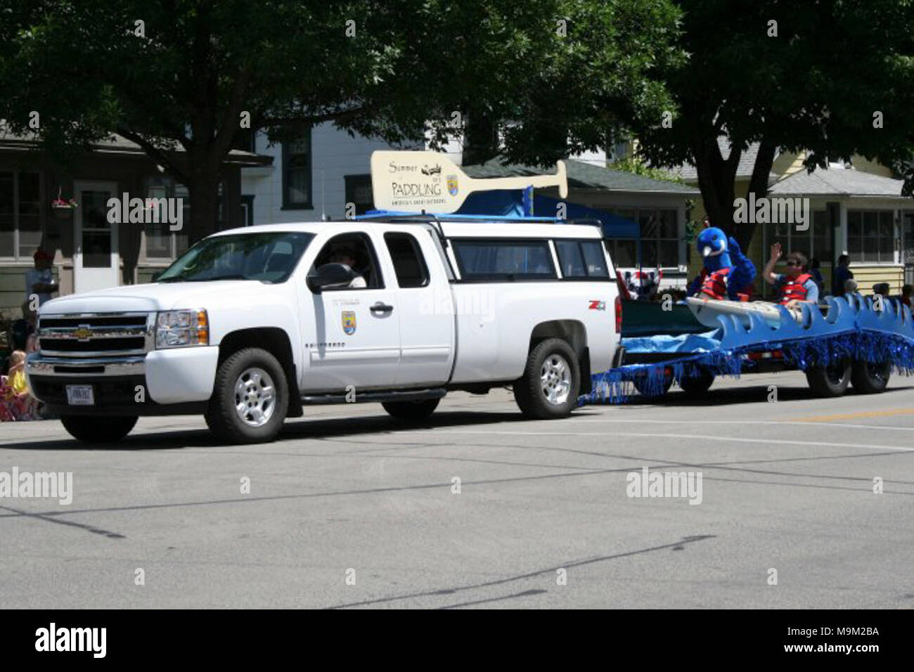 Wildnisbiologe Brian Stemper Wellen an, zu den Volksmengen, und ziehen Sie gleichzeitig die Sommer Paddeln schwimmen in der Steamboat Days Parade in Winona, MN statt. Foto von Stefanski/USFWS. Stockfoto