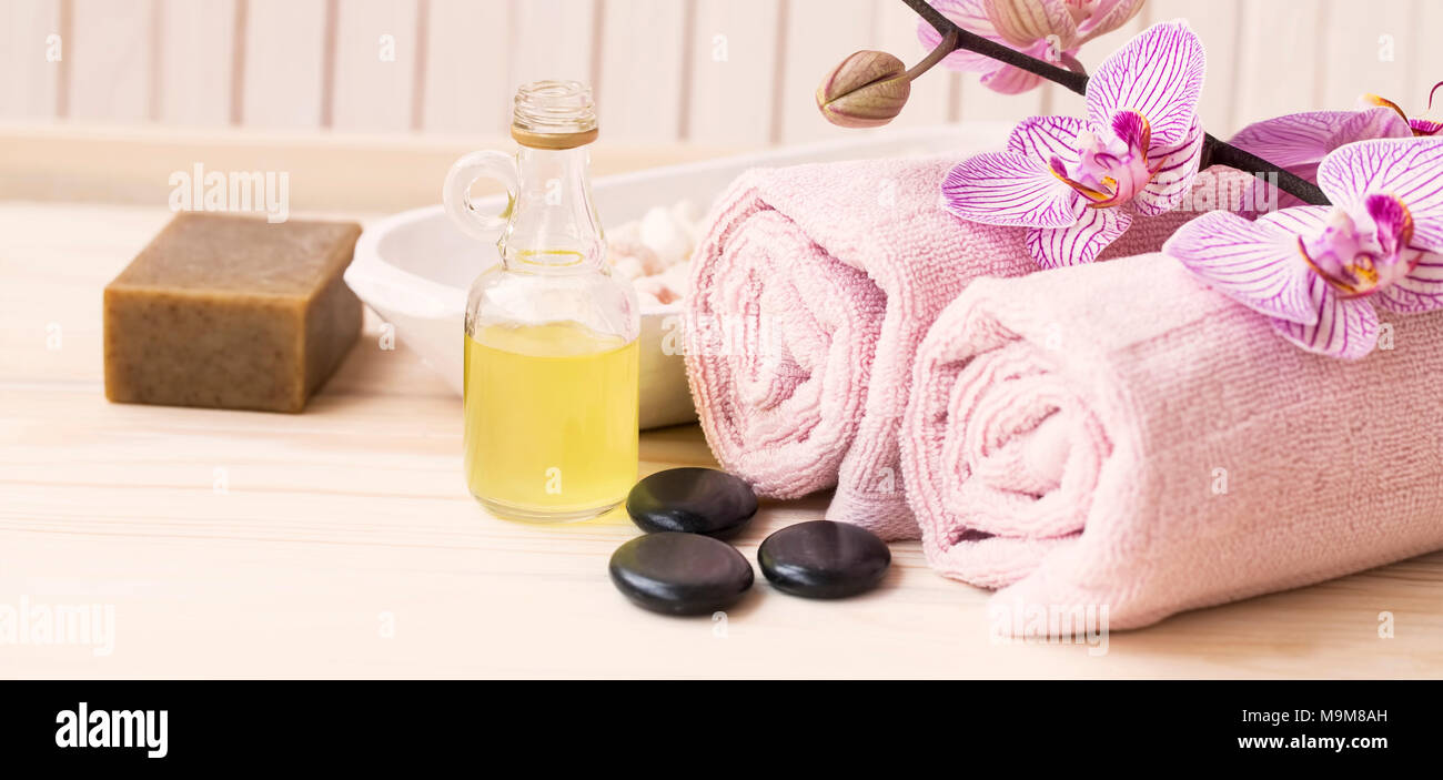 Spa Noch leben Einstellung mit Öl Flasche, Orchidee, natürliche Seife, Massage Steine und Handtücher aus Baumwolle auf hölzernen Hintergrund Stockfoto