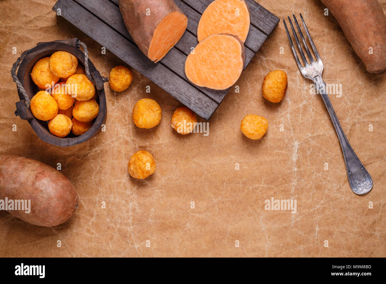 Süsse Kartoffel Kroketten auf braunem Papier Hintergrund, Platz für Ihren Text Stockfoto