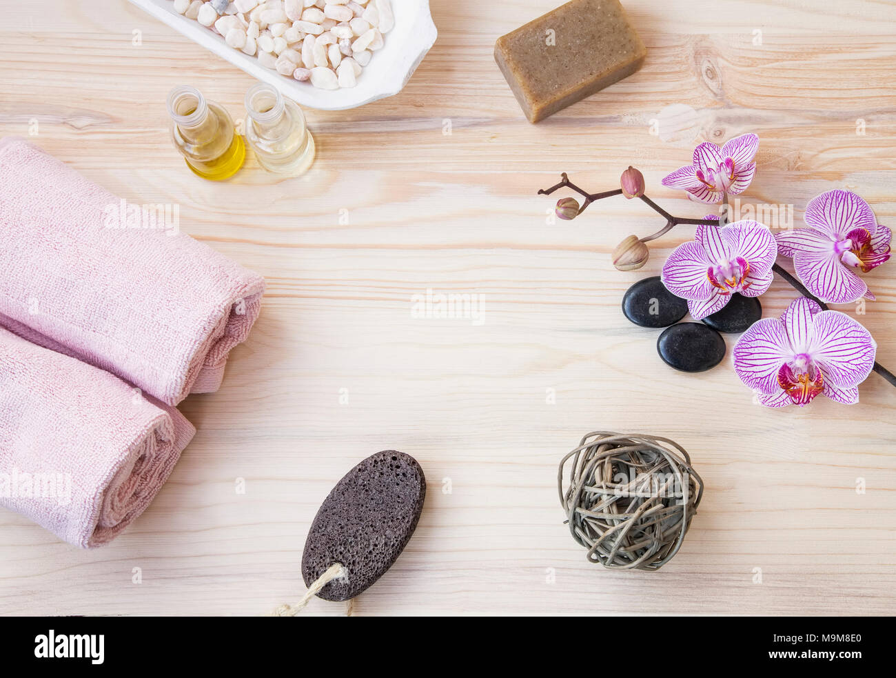 Spa Noch leben Draufsicht mit Handtücher, Salz, Öl Flaschen, natürliche Seife, Orchidee Blumen und Massage Steine auf Holz- Hintergrund Stockfoto