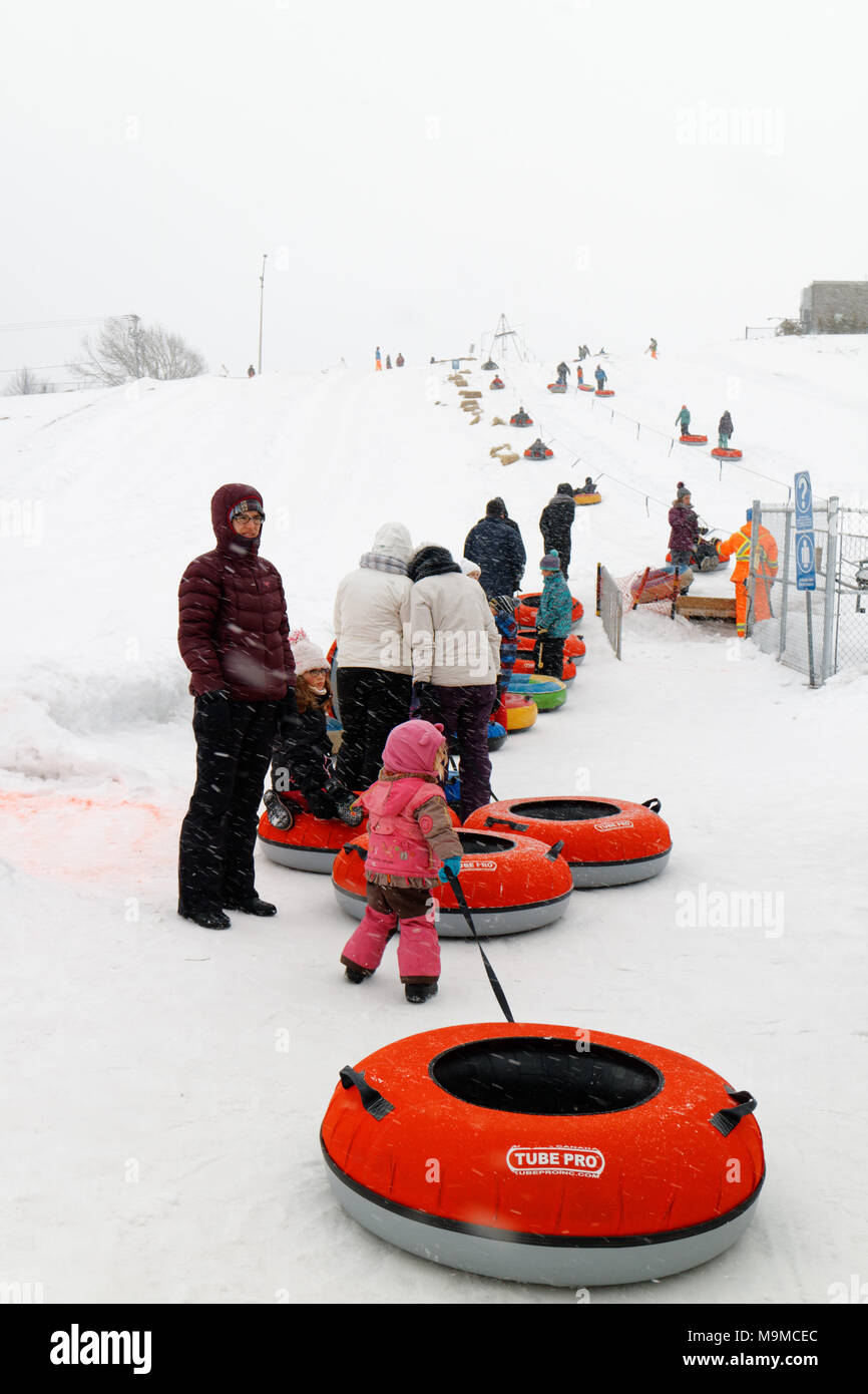 Eine Warteschlange von Menschen mit Gummi Ringe für die Seilbahn zu gehen Schiebetüren in Rimouski Parc Beausejour, Quebec, Kanada warten Stockfoto