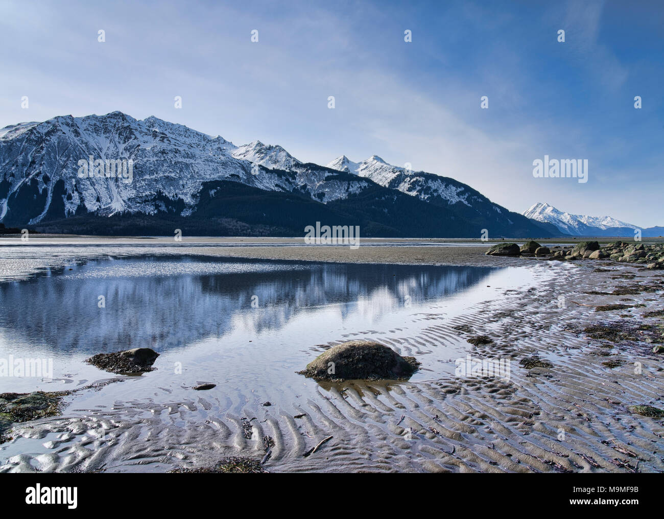 Chilkat Berge in Wasser in der Gezeiten- Mündung des Chilkat Einlass im Winter wider. Stockfoto