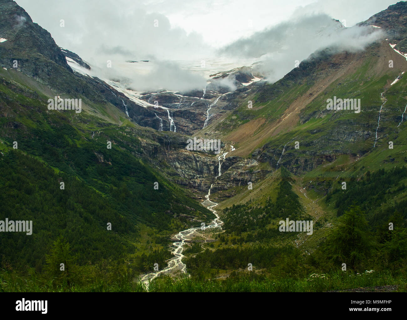 Eiszeit Wasserfälle hinunter Berghänge bilden einen Fluss, der durch das Tal in der Schweiz Stockfoto