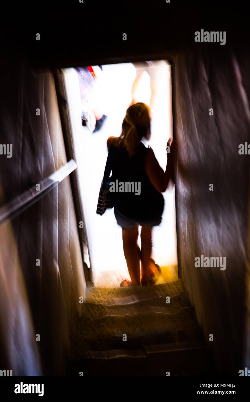 Silhouette einer Frau in einem Türrahmen über zu Schritt in einer geschäftigen Stadt Stockfoto