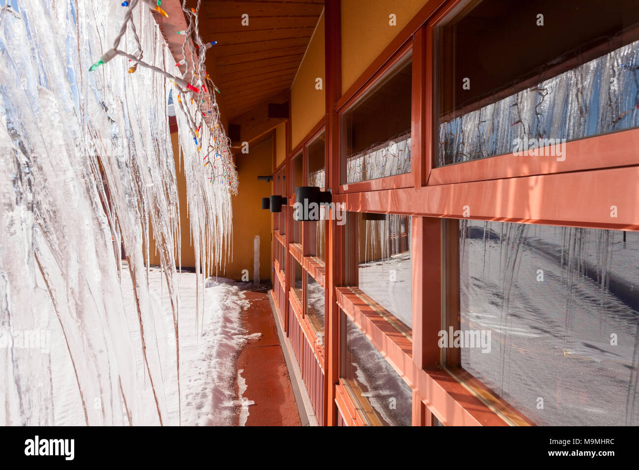 Große Eiszapfen hängen von einem Gebäude. Huntsville, Ontario, Kanada. Stockfoto