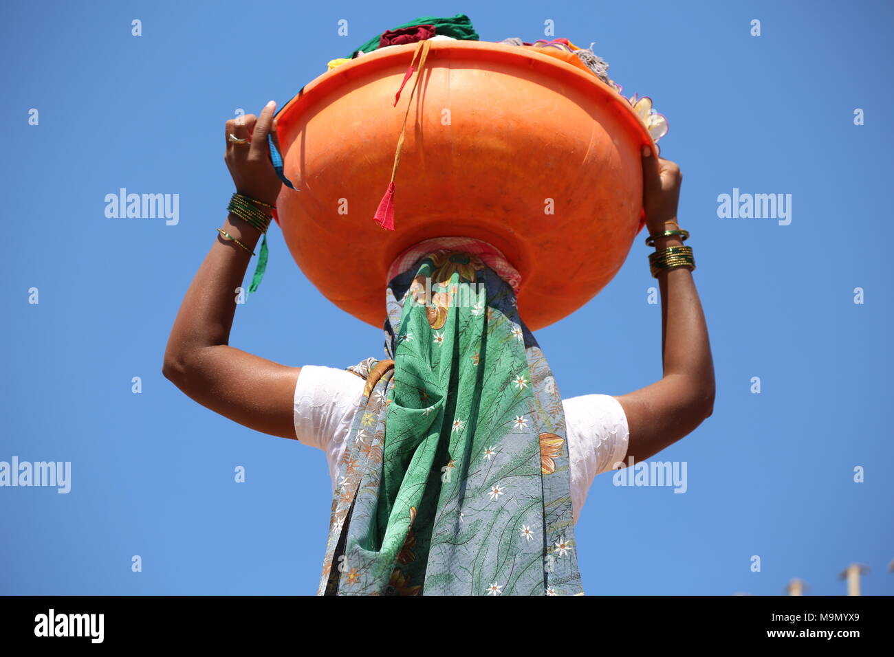 Indische Frau nach dem Waschen der Wäsche mit waschen Schüssel auf dem Kopf - Indische Frau / dem Wäsche waschen mit Waschschüssel mit dem Kopf Stockfoto