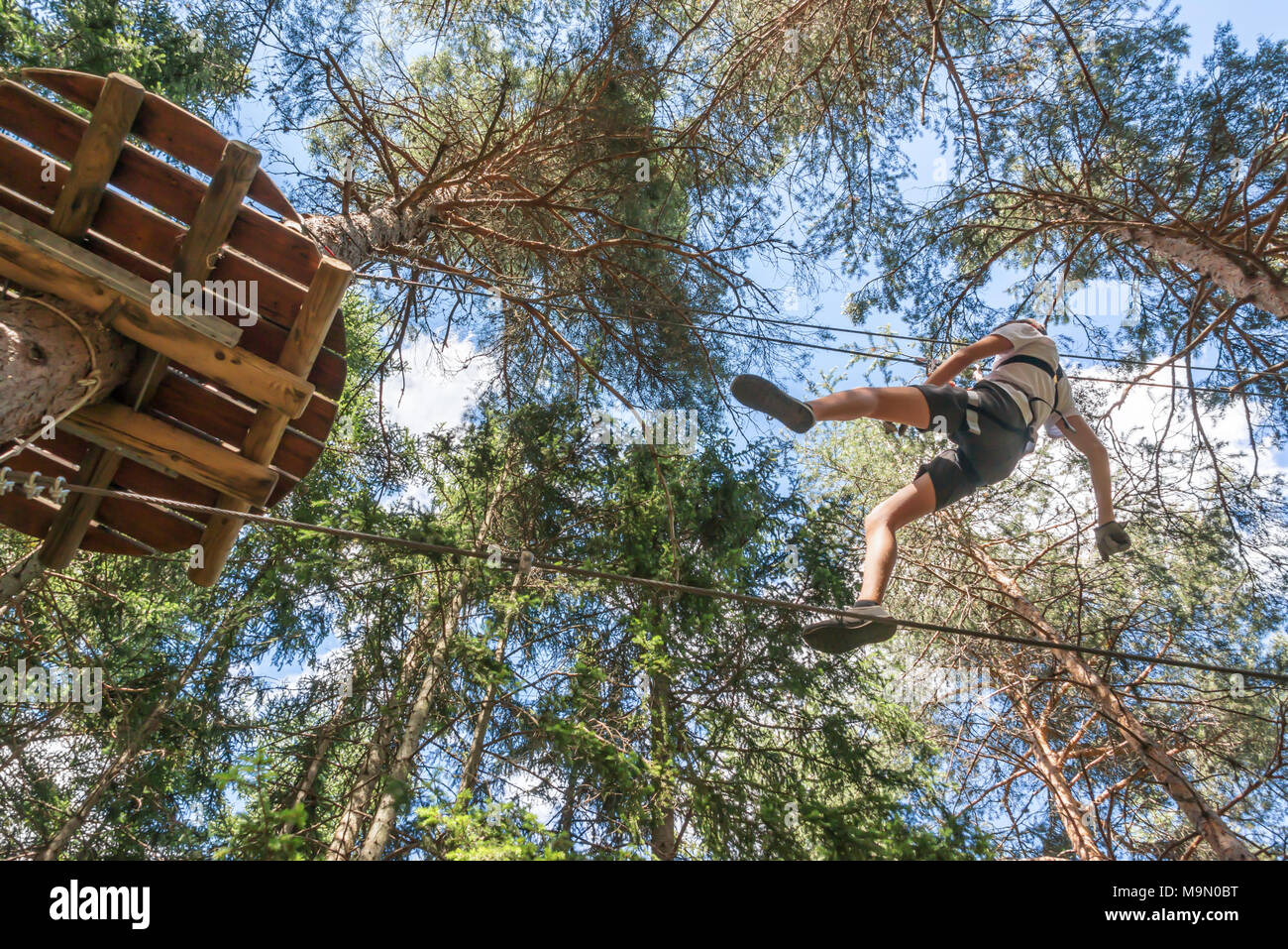 Teenager Spaß im Hochseilgarten, Abenteuer Park, Klettern Bäume in einem Wald im Sommer Stockfoto