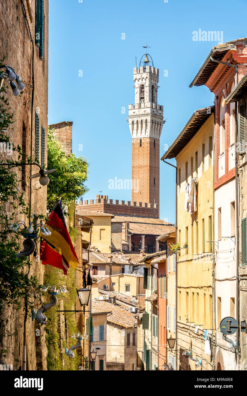 Gasse in Siena, mit Blick auf den Torre del Mangia, Toskana, Italien Stockfoto