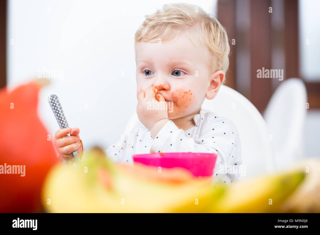 Porträt einer niedlichen unordentlich Baby Mädchen essen mit den Händen Stockfoto