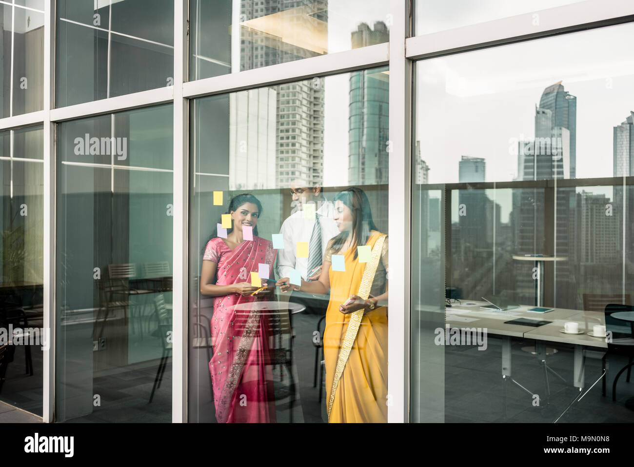 Indische Mitarbeiter haften Erinnerungen auf Glas Wand im Büro Stockfoto