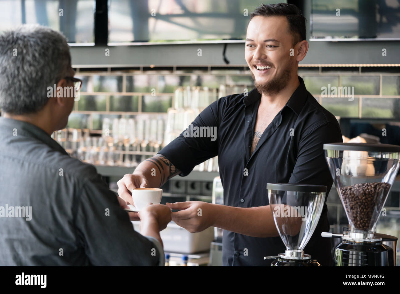 Barkeeper serviert Espresso mit einem Kunden Stockfoto