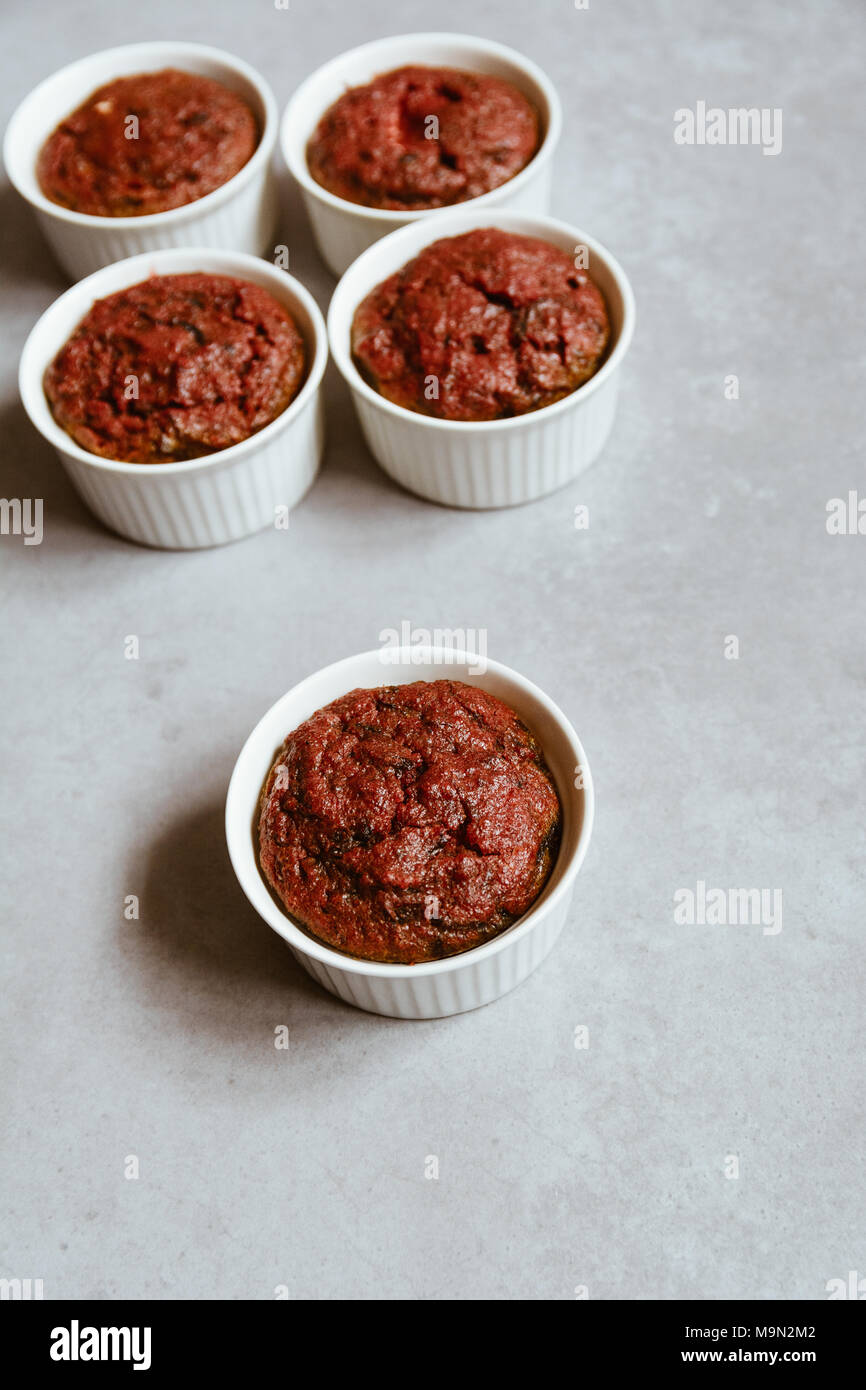 Gesund vegan Rote Bete Muffins in weißen Tassen auf rustikalen Bord. Festliche Komposition, kopieren Platzverhältnisse, geringe Tiefenschärfe. Film Stil. Stockfoto