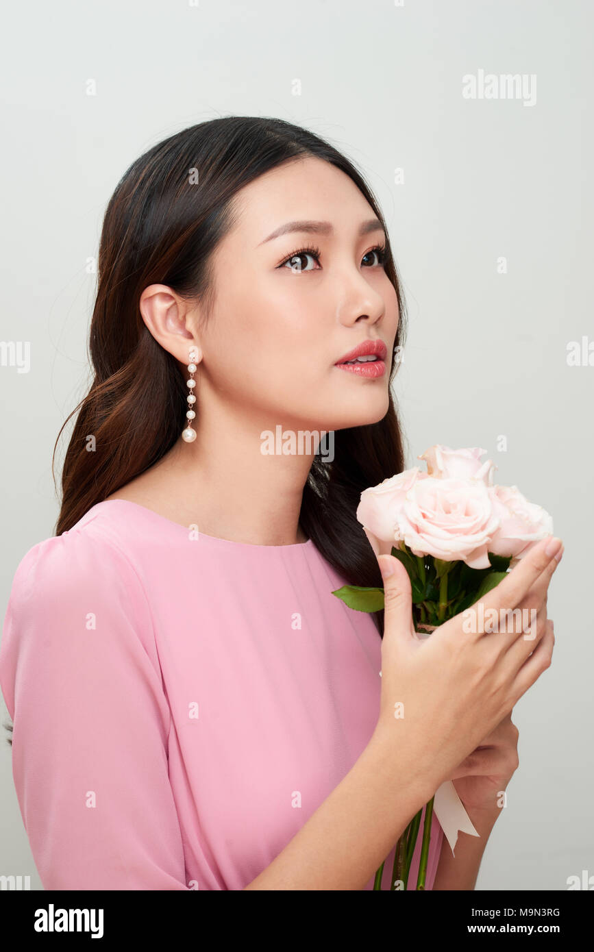 Schöne asiatische Mädchen mit Blumen. Perfekte Haut. Stockfoto