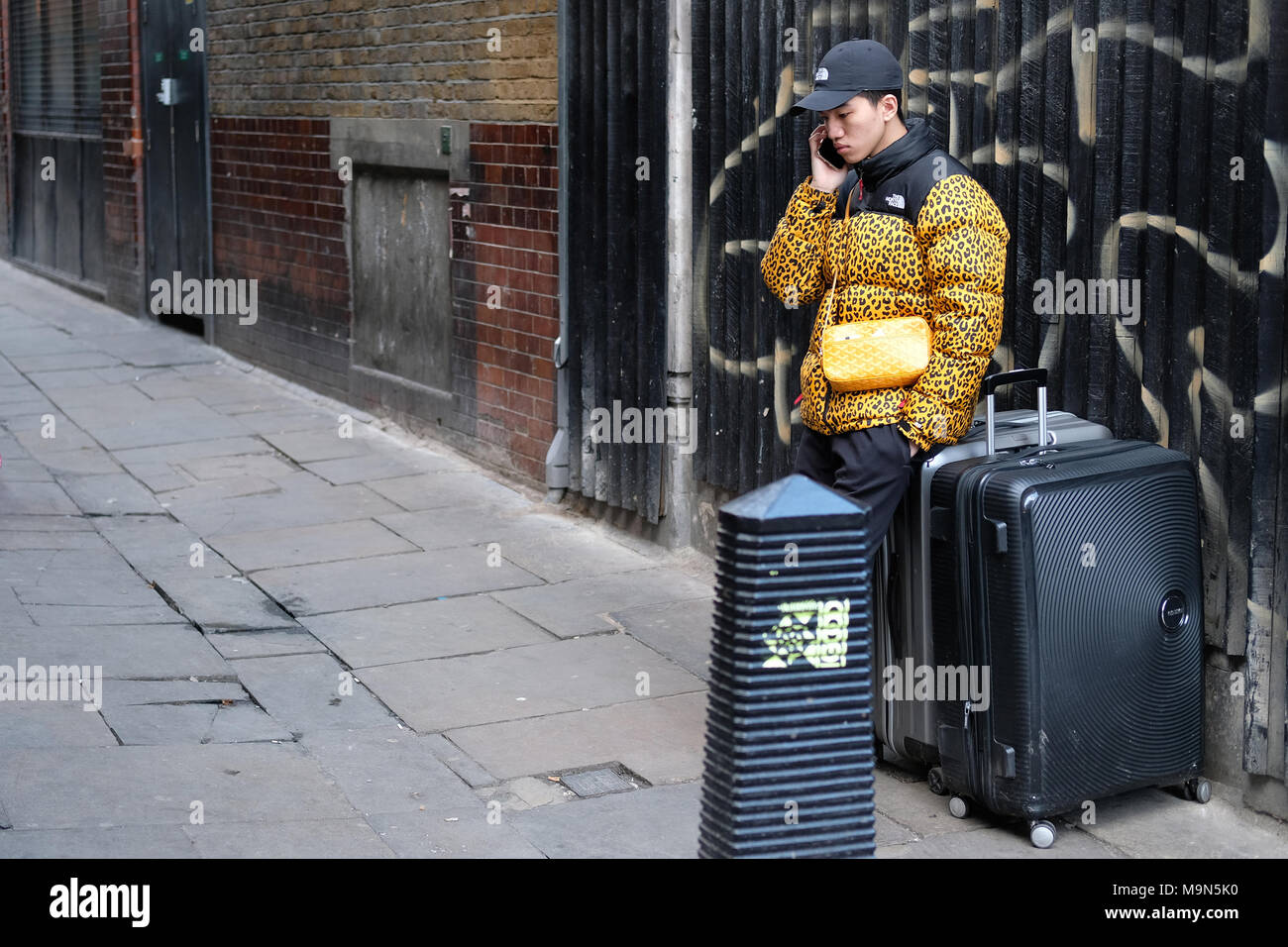 Ein Tourist über sein Telefon in Soho, London. Stockfoto