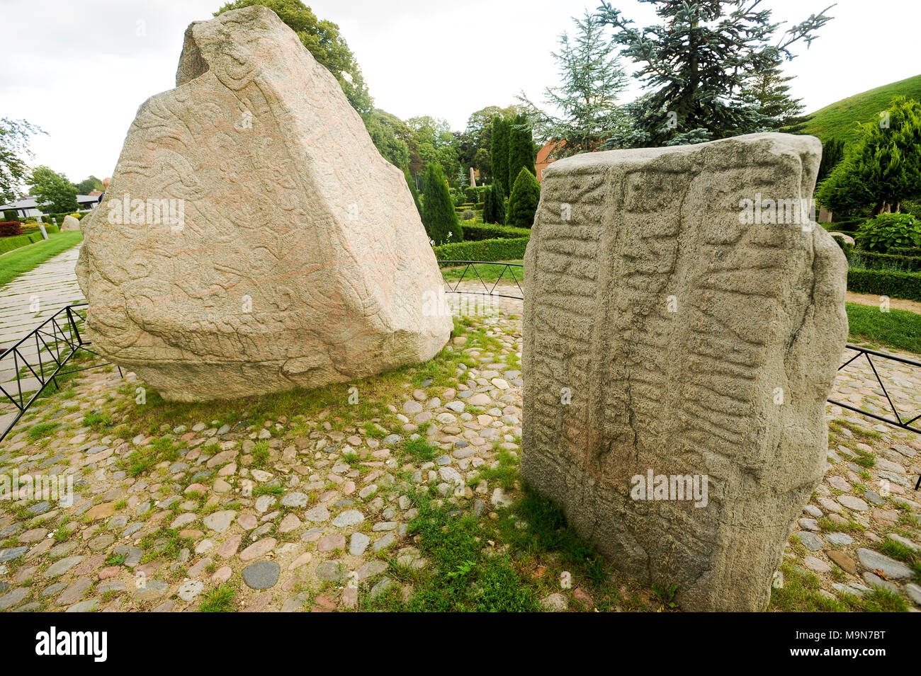 Massive geschnitzten runestones Jellingstenene (Jelling Steine) von X Jahrhundert, auf der linken Seite König Harald von der Bluetooth Gormsson runenstein von 983 in Erinnerung an Stockfoto