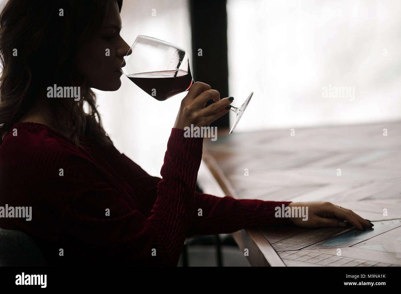 Das Mädchen ist das trinken Rotwein Stockfoto