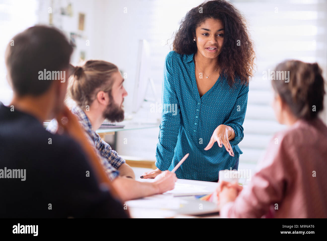 Treffen Im. eine schwarze Frau diskutiert mit ihren Kollegen Stockfoto