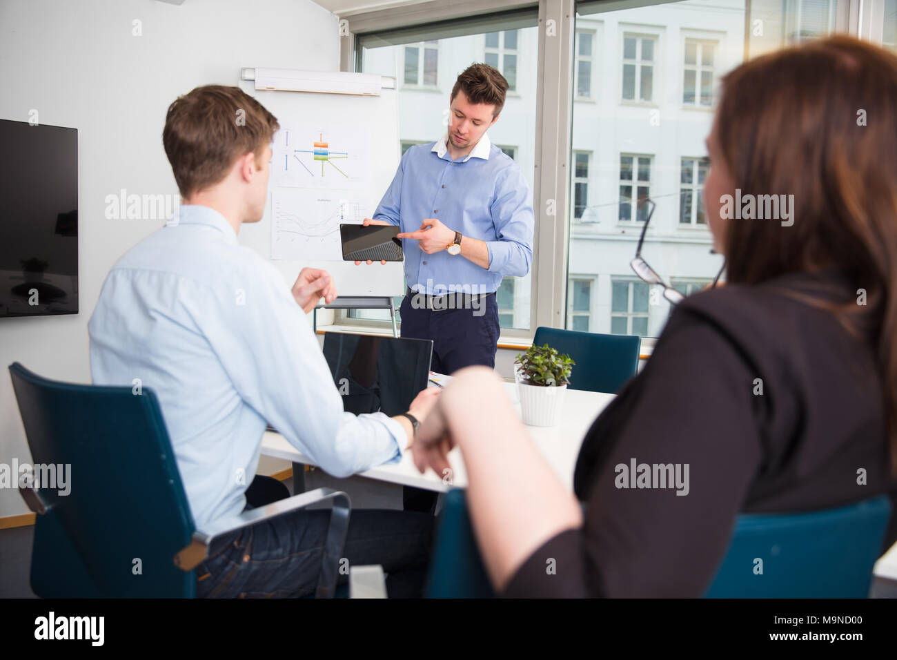 Geschäftsmann mit Tablet-PC an Mitarbeiter Stockfoto