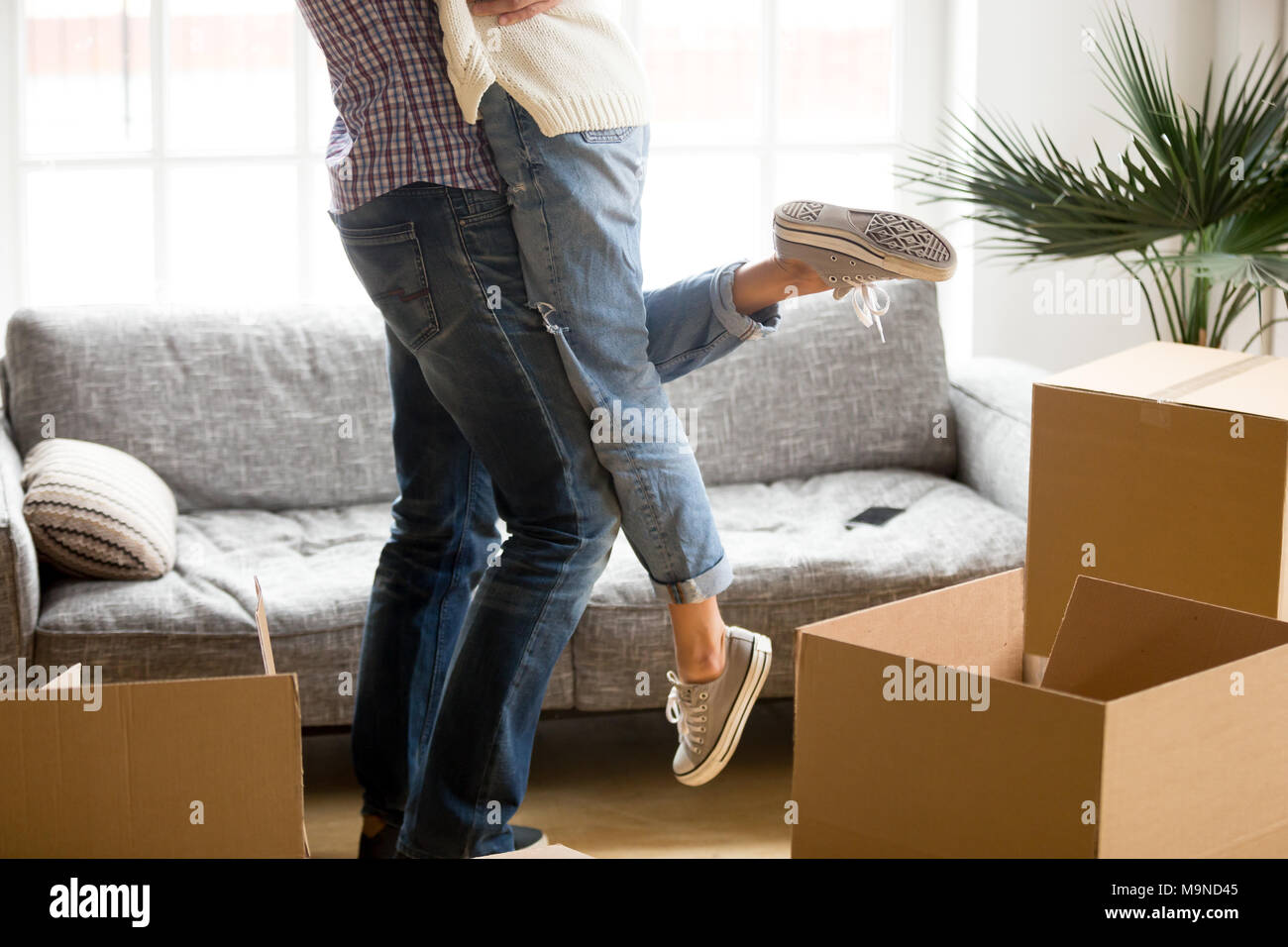 Glückliches Paar am Umzugstag Konzept, Mann, Frau, heben unter Kartons starten zusammen Leben im neuen Haus, Mann Holding embrac Stockfoto