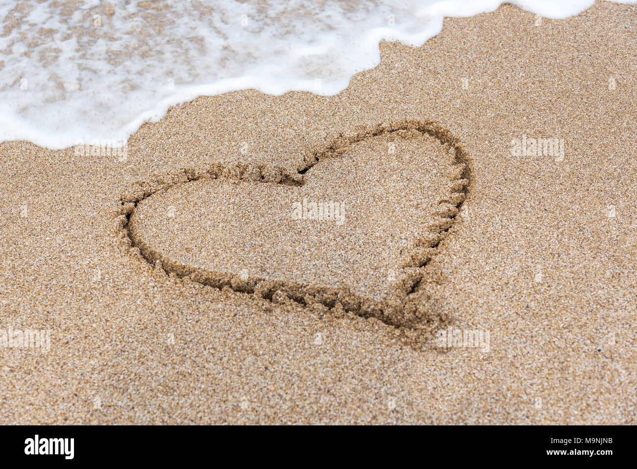 Zeichnung Herz auf der Sand des Meeres. Stockfoto