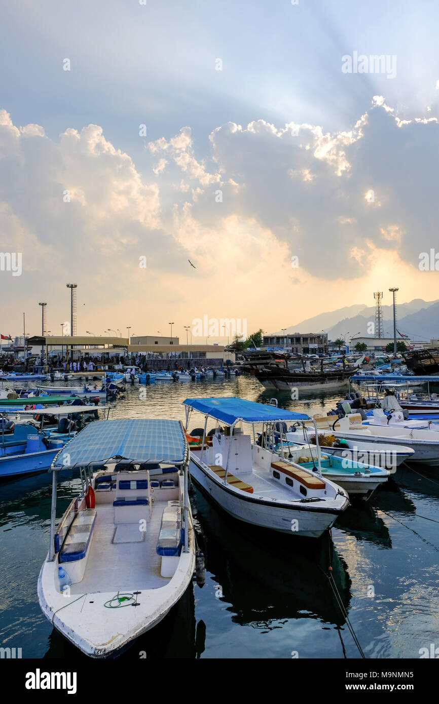 Boote angedockt an Musandam (Oman), Sonnenstrahlen durch die Wolken bei Sonnenuntergang kommen Stockfoto