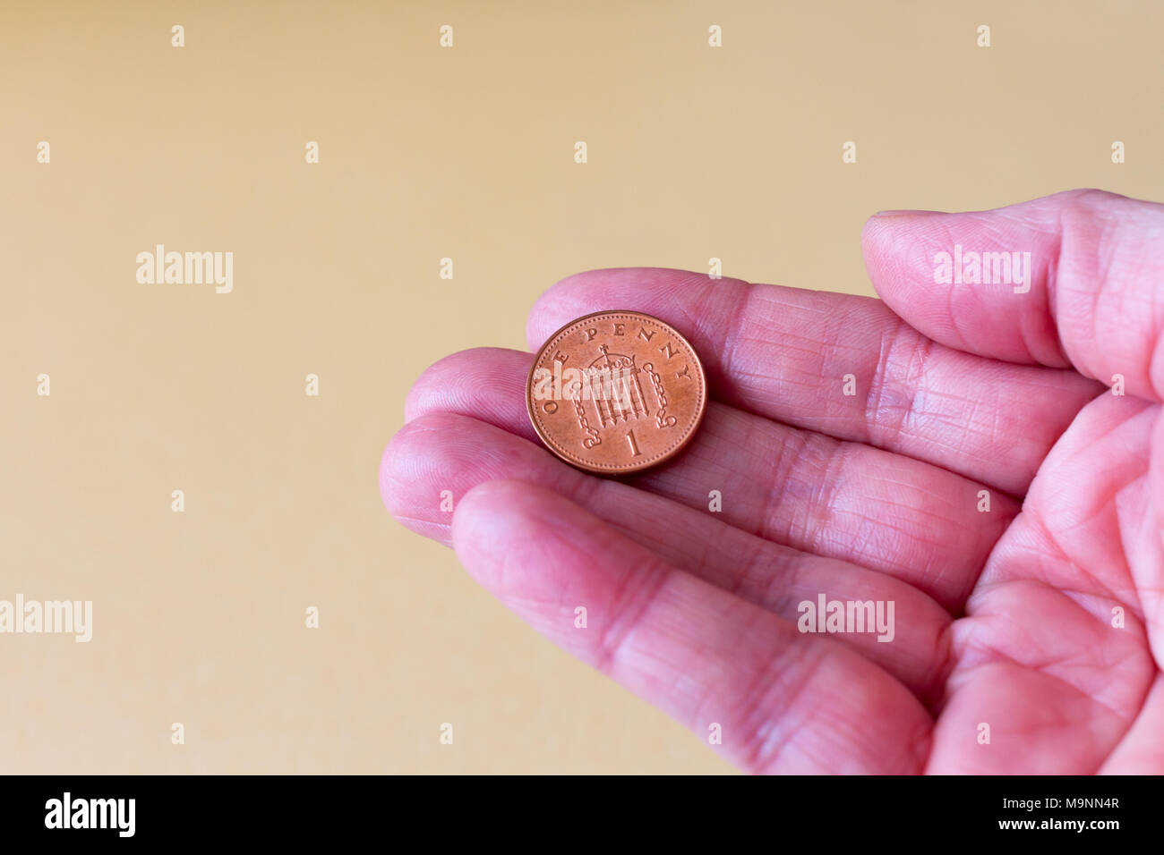 Weibliche Hand, die eine Britische Pfund einen Pence (Penny) Münze, Vereinigtes Königreich Stockfoto