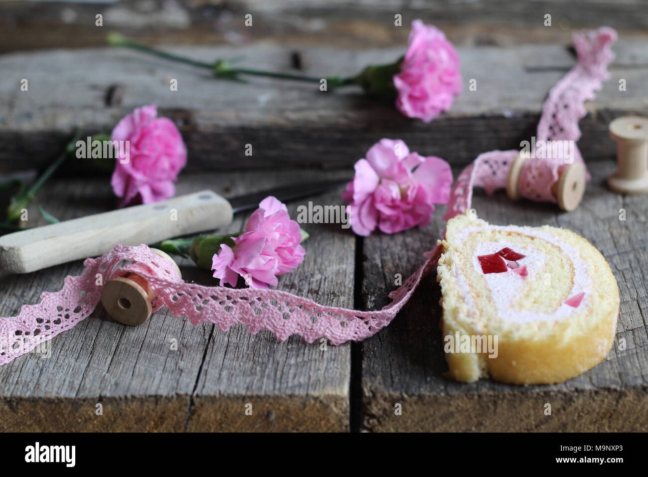 Dough biscuit Rollen, Spulen und Pink carnation Blüten auf Holz-, vintage Hintergrund - Flach essen Hintergrund Stockfoto