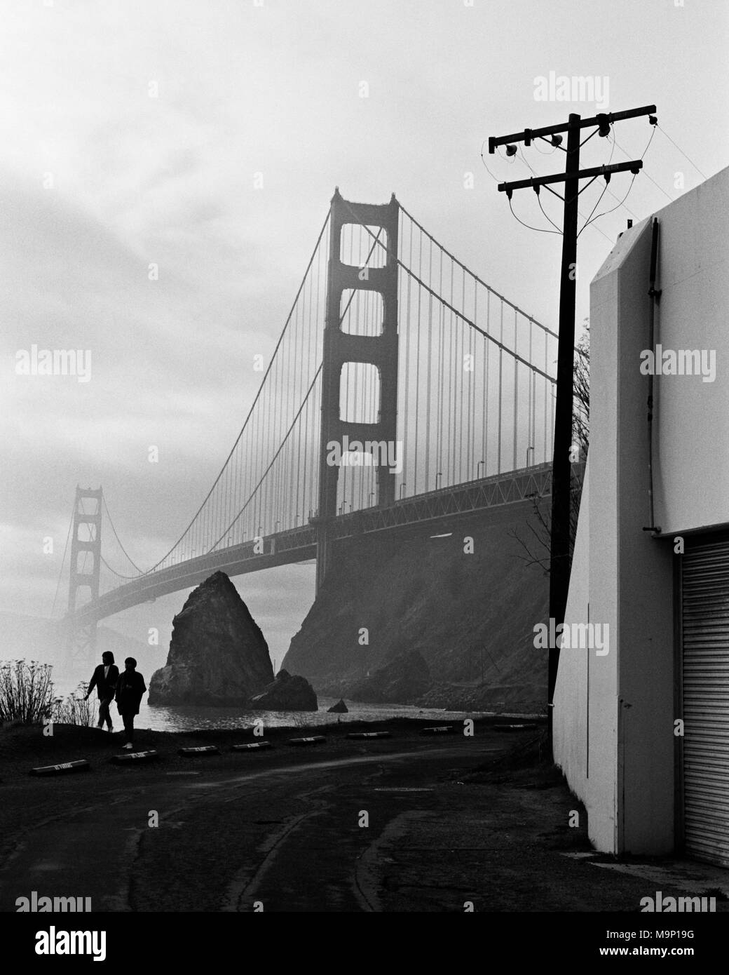 Eine Silhouette Paar entlang das Wasser mit der Golden Gate Bridge im Hintergrund. Golden Gate National Recreation Area, Marin County, Kalifornien. Stockfoto