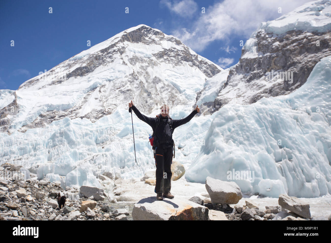 Gerne männliche Wanderer mit den Händen in der Luft im Everest Base Camp, Khumbu, Nepal Stockfoto