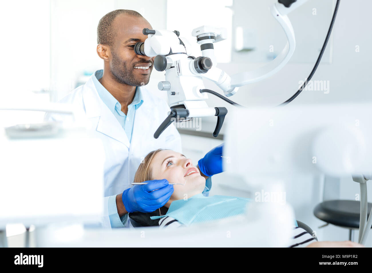 Angenehme Zahnarzt Prüfung auf Risse in Patienten Zähne Stockfoto