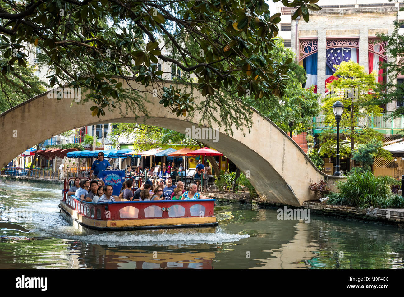 Eine Menschenmenge Fahrt im Wassertaxi entlang des San Antonio River Walk auf einer sonnigen Spätsommer Tag. Stockfoto
