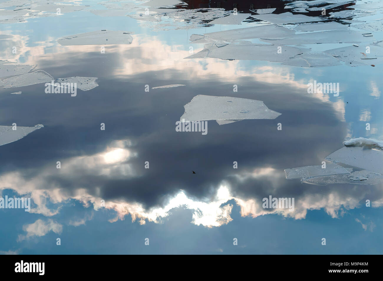 Feder, Reflexion wolken Wasser, Eis schwimmt, Sonne und Wolken in Schollen und Wasser Stockfoto