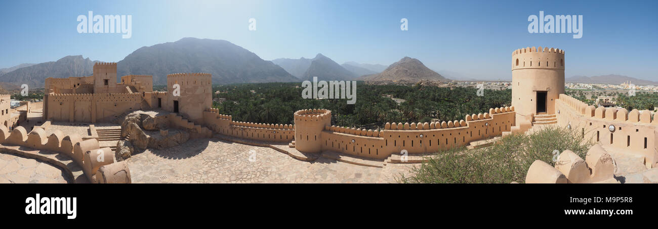 Festung von nakhl mit runden Turm und Zinnen, an der Rückseite Hajar Berge, Panoramaaussicht, Nakhl, Oman Stockfoto